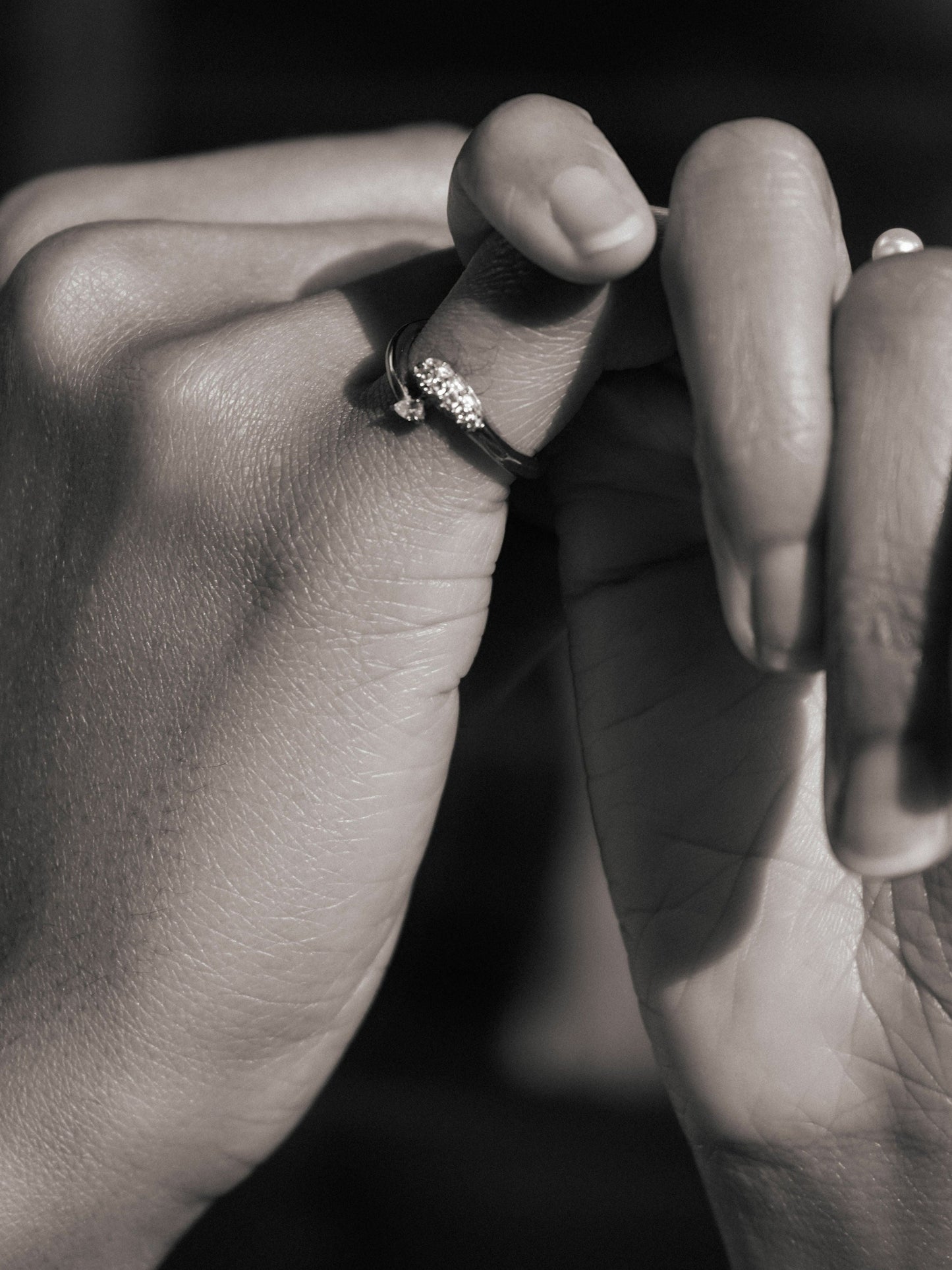 Elegant silver ring with sparkling stones on a hand, showcasing a stylish and modern design.