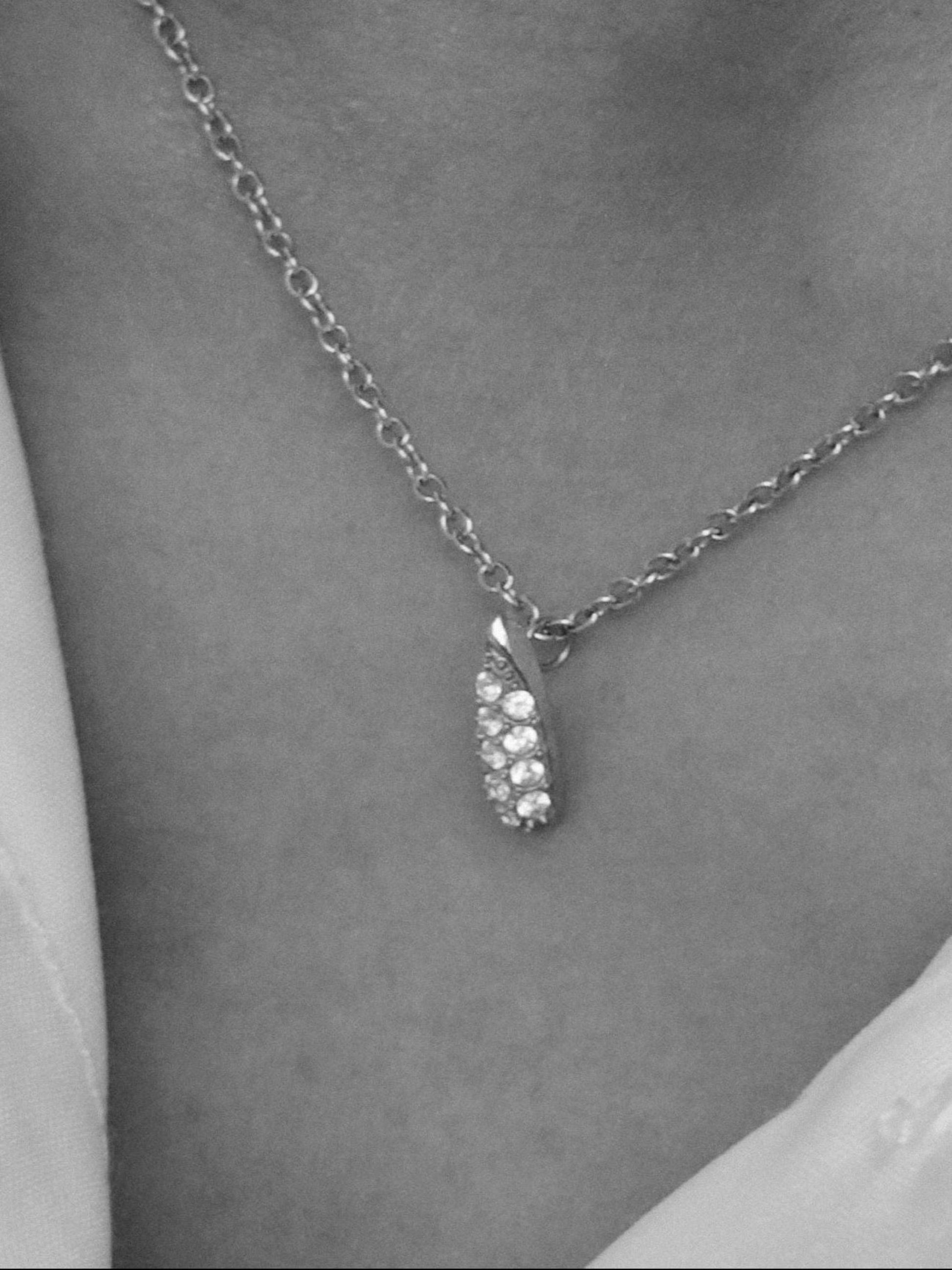 Silver chain necklace with a sparkling crystal leaf pendant, elegant and stylish accessory for any outfit.