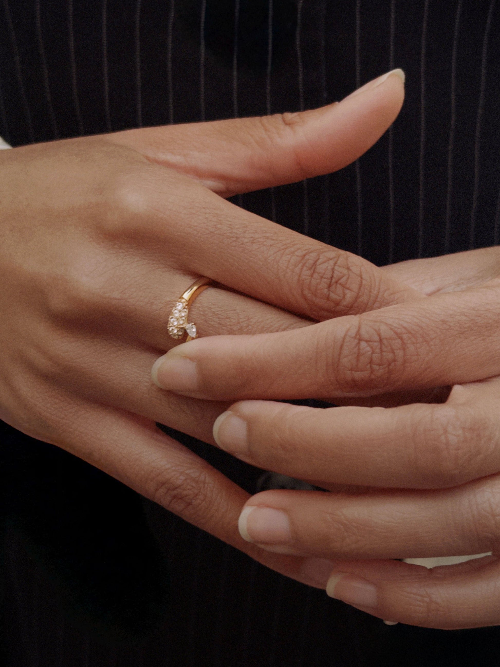 Elegant gold ring with sparkling diamonds, set on a hand with natural nails, perfect for any occasion.