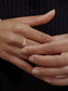 Elegant gold ring with sparkling diamonds, set on a hand with natural nails, perfect for any occasion.