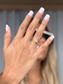 Elegant gold ring with sparkling stones, showcased on a hand with French manicure.